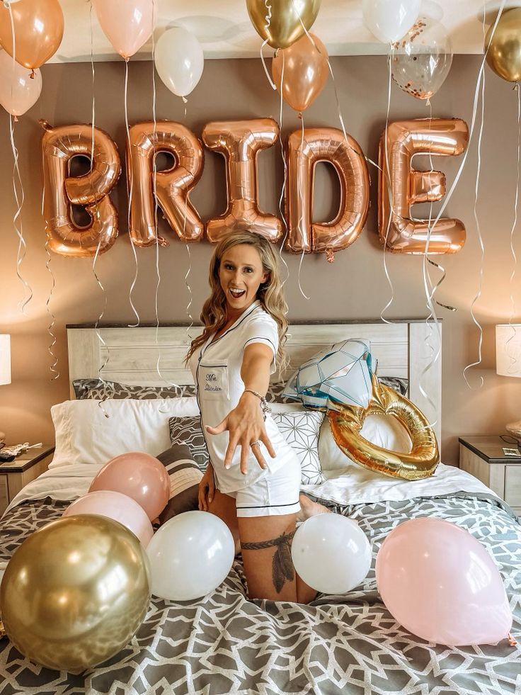 a woman is standing on her bed with balloons in front of her and the word bride above her