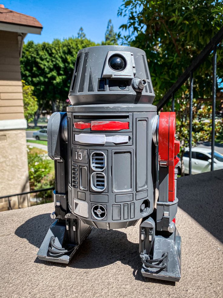 a star wars r2d2 figure is shown on the sidewalk in front of a house