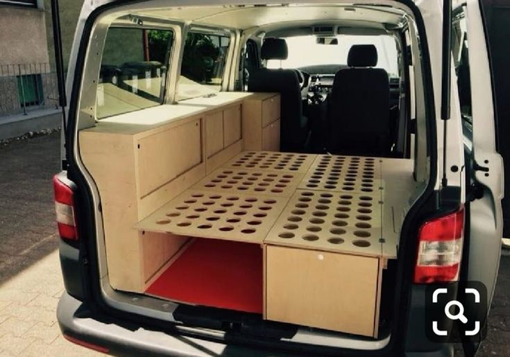 the back end of a van with an open hatchback and cargo tray in it