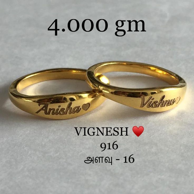 two gold wedding rings with names engraved on the sides, and hearts in each ring