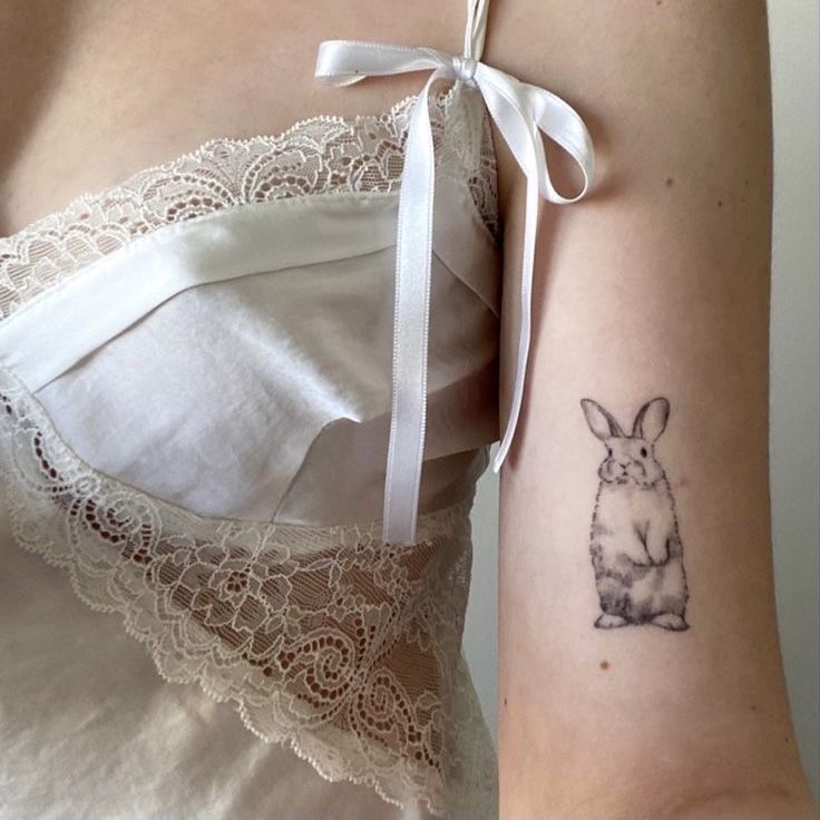 a woman's arm with a rabbit tattoo on it