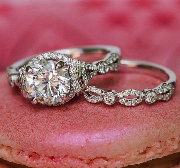 two engagement rings sitting on top of a pink donut