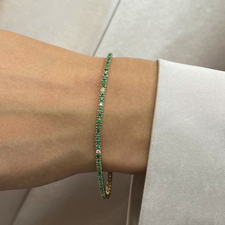 This Beautifully Crafted Tennis Bracelet Features Round Cut Green Emeralds And Diamonds Encrusted In Four Prong Setting. Crafted In 14k Yellow Gold. Total Diamond Weight: 0.09 Carat. Diamond Quality: G-H Color And Vs-Si Clarity. Total Emerald Weight: 1.98 Carats. Length: 7 Inches. Width: 2.3 Mm. Total Weight: 6.61 Gms. Bracelet Closes Securely With A Box Clasp. This Tennis Bracelet Is A Timeless Piece That Holds A Place In The Collection Of Every Jewelry Lover. Comes With A Presentable Gift Box Emerald Tennis Bracelet, Pink Gold Bracelet, Shiny Bracelets, Hand Cuff Bracelet, Crystal Anklet, Gold Bracelet Set, Glass Bangles, Emerald Bracelet, Bangle Ring