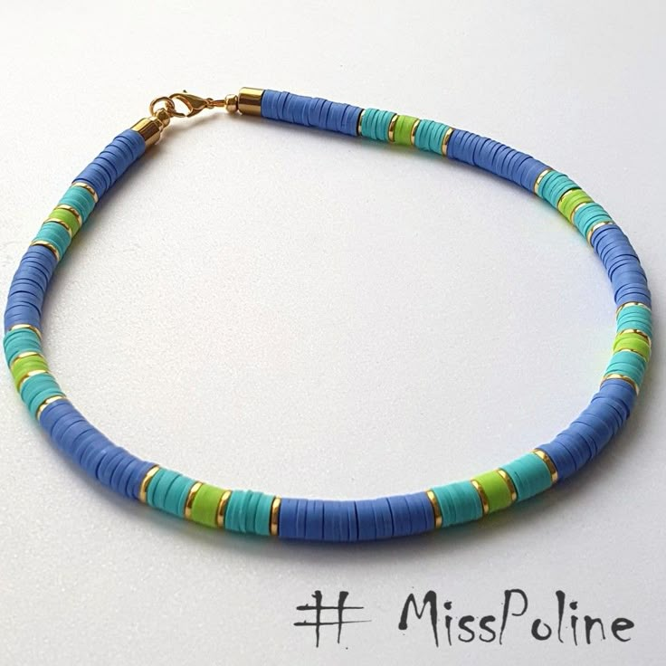 a blue and green beaded necklace on a white surface with the word misspoline written below it