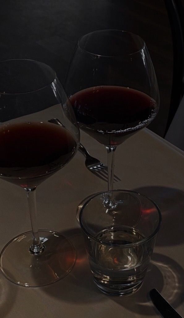 two glasses of wine sitting on top of a table