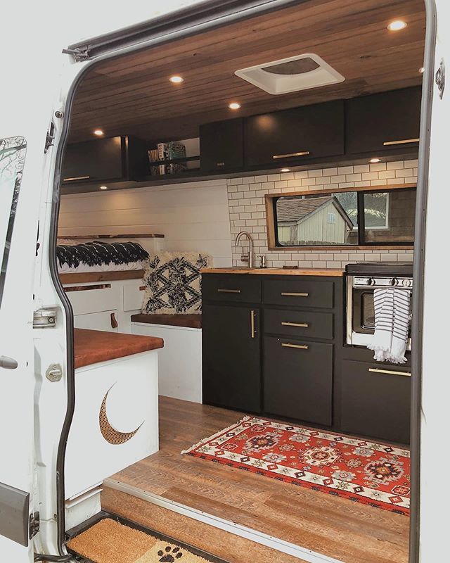 the interior of a camper van with its door open and kitchen area in view