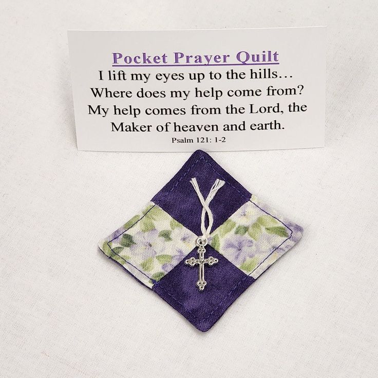 a piece of cloth with a cross on it next to a card that says pocket prayer quilt