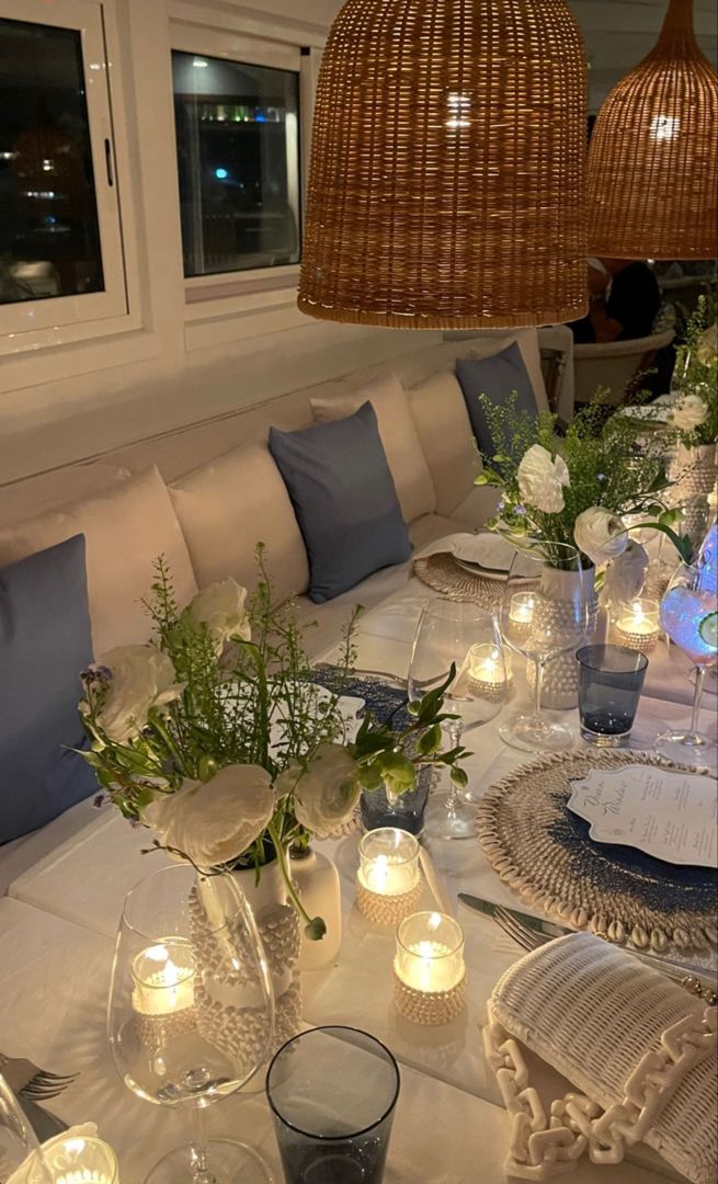 a dining room table set with candles and flowers on the centerpieces for an elegant dinner