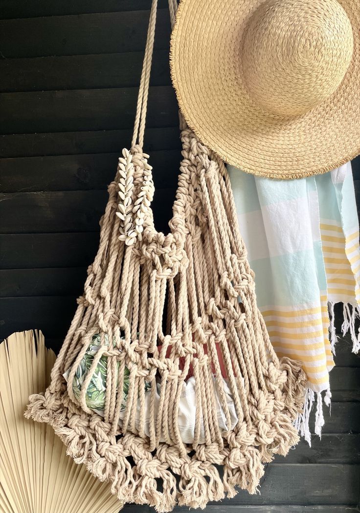 a straw hat hanging from the side of a wall next to a purse and fan