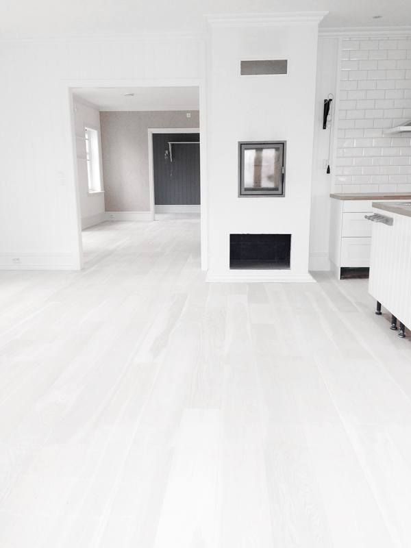 an empty living room with white walls and wood floors