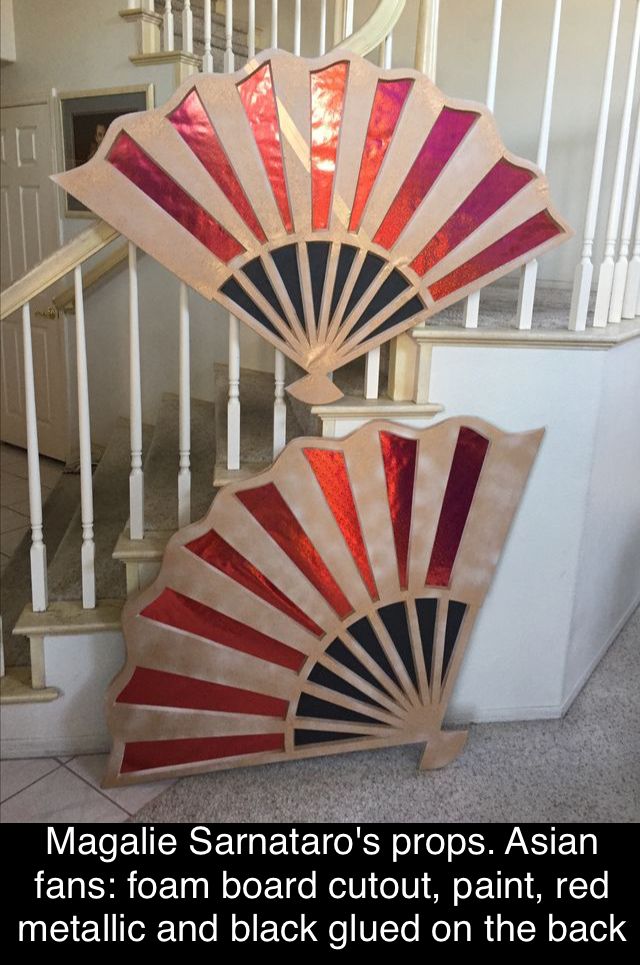 two stained glass fan sitting on the ground next to a stair case in a house