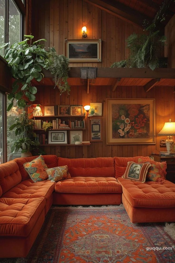 a living room with an orange sectional couch and potted plants on the wall above it