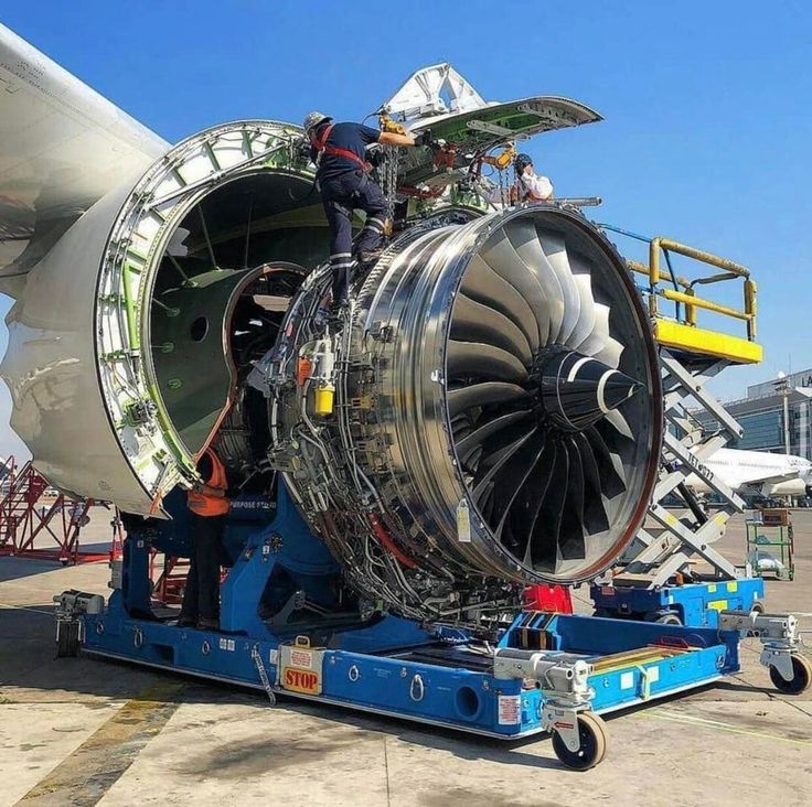 an airplane engine being worked on by workers