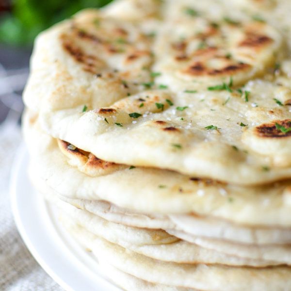 a stack of pita bread sitting on top of a white plate