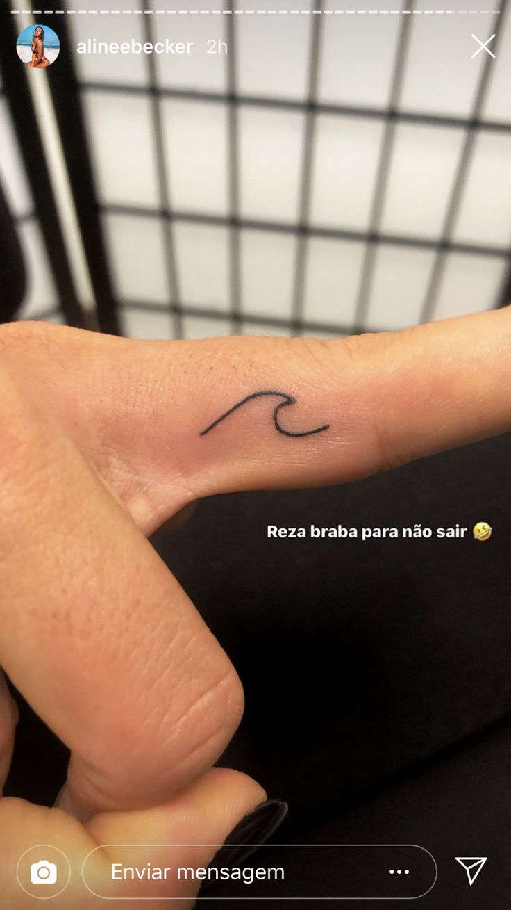 a person's hand with a small wave tattoo on it