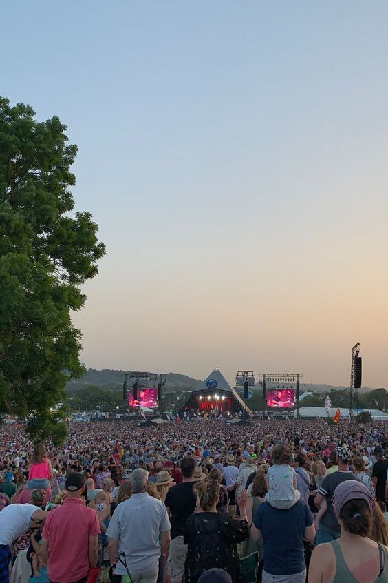 a large group of people standing in front of a crowd at a music festival or concert