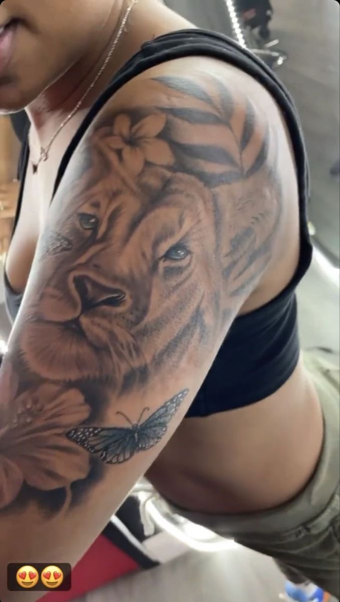 a woman with a tiger and flower tattoo on her arm is taking a selfie