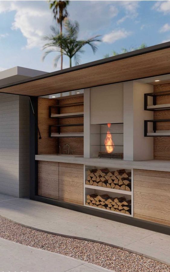 an outdoor fireplace is built into the side of a building with shelves and firewood