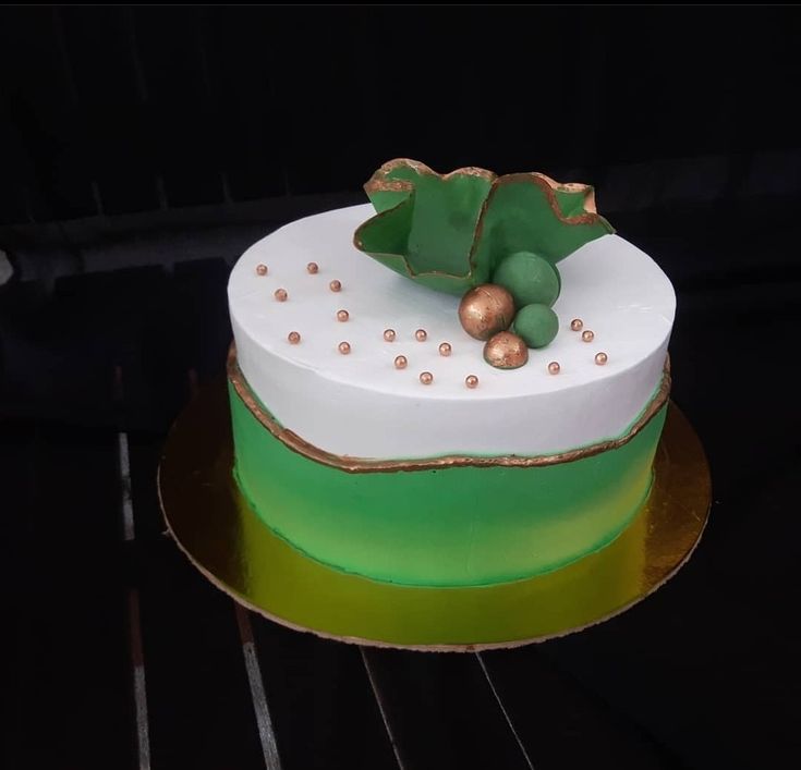 a green and white cake with gold decorations