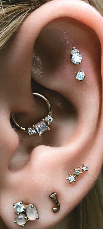 an ear with three different types of piercings on it