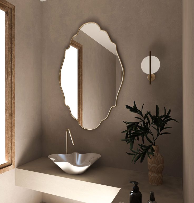 a bathroom with a sink, mirror and vase on the counter top next to it