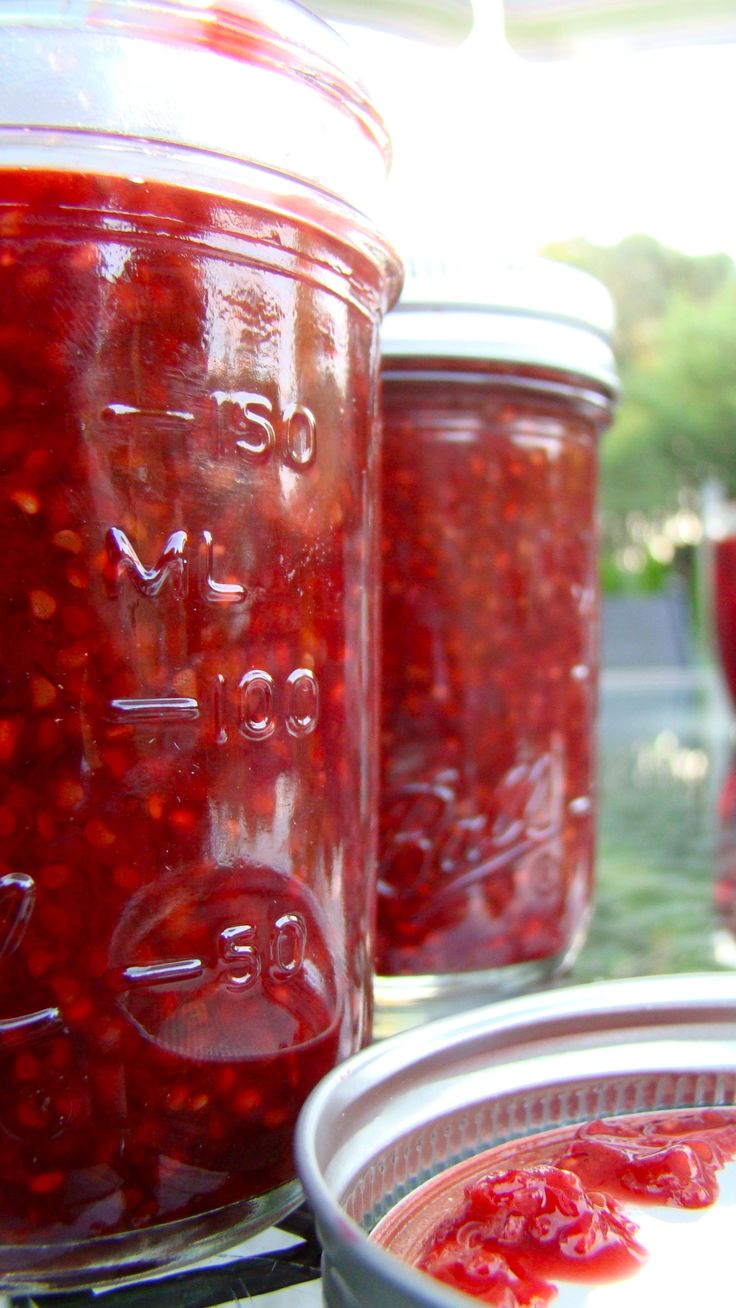 jars filled with red liquid sitting on top of a table