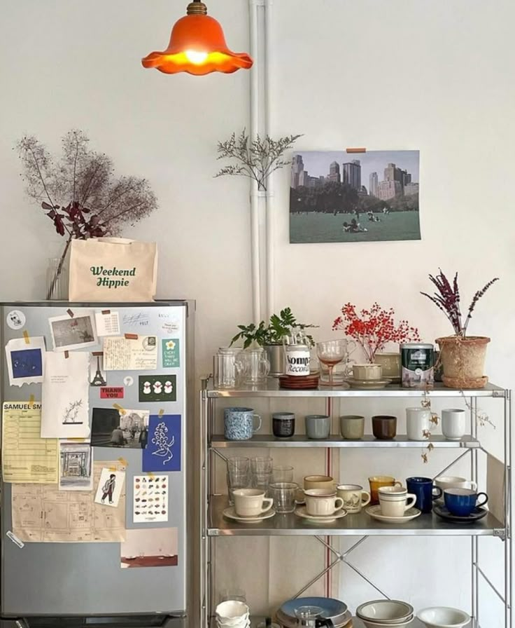 a shelf with plates, cups and bowls on it in front of a light fixture