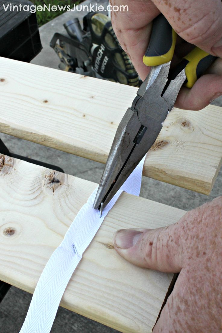 a person cutting wood with a pair of scissors