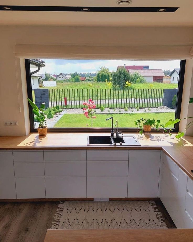 a kitchen with an open window overlooking the yard