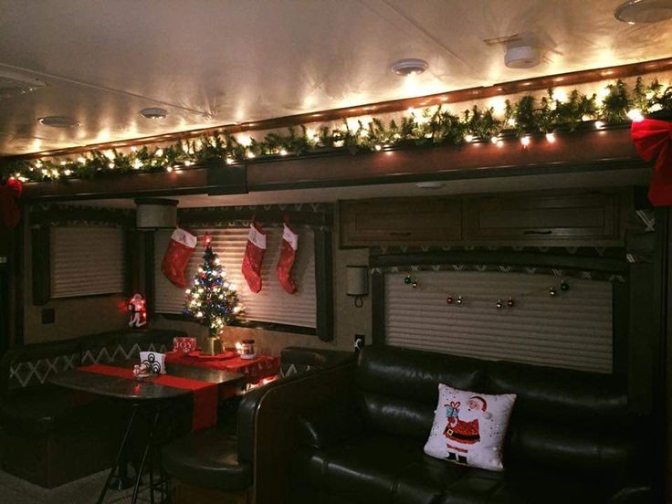 an rv decorated for christmas with stockings and lights on the ceiling, along with other decorations