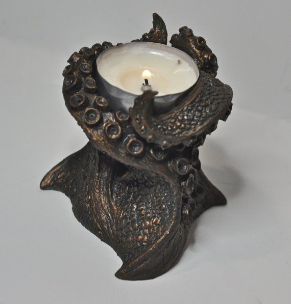 an ornate candle holder with a lit candle in the shape of a bird on it