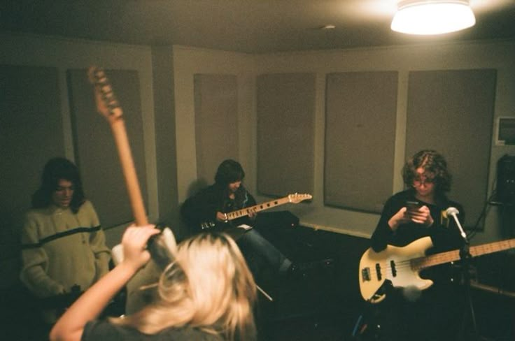 a group of people in a room with guitars