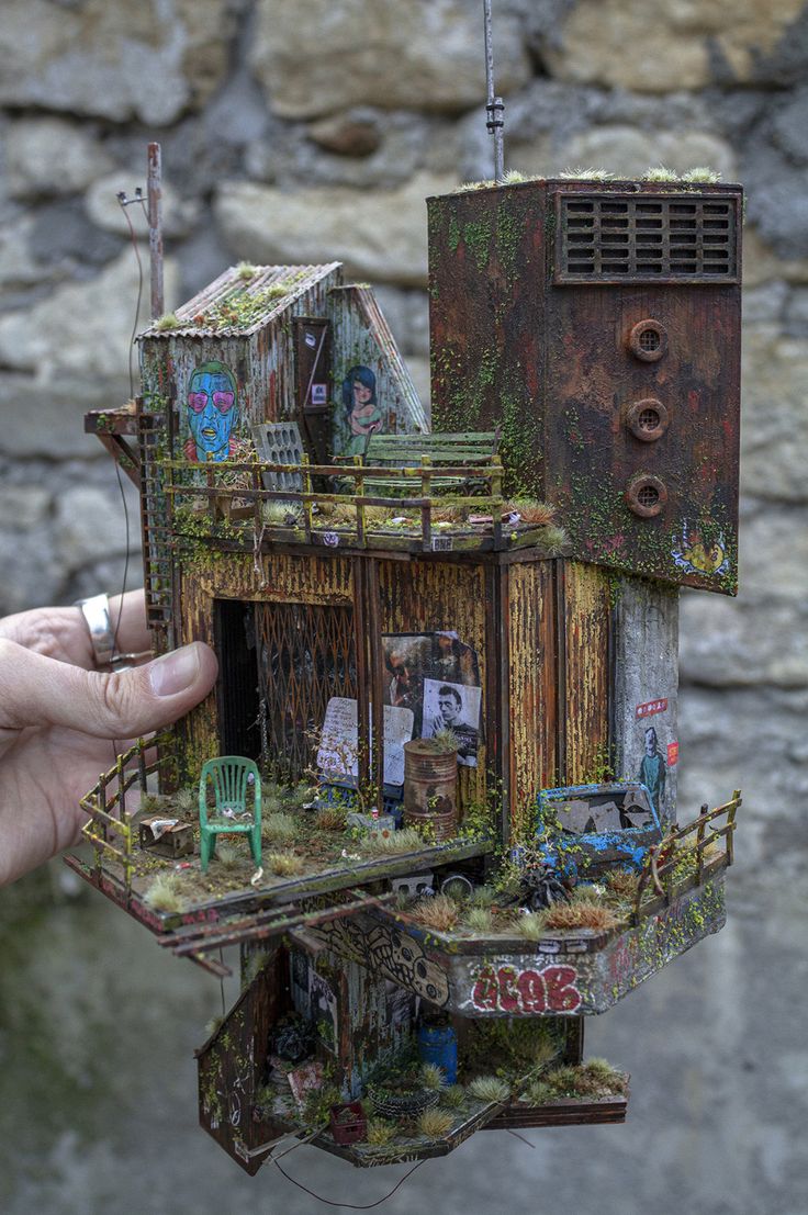 a miniature house made out of junk with lots of windows and doors on the roof