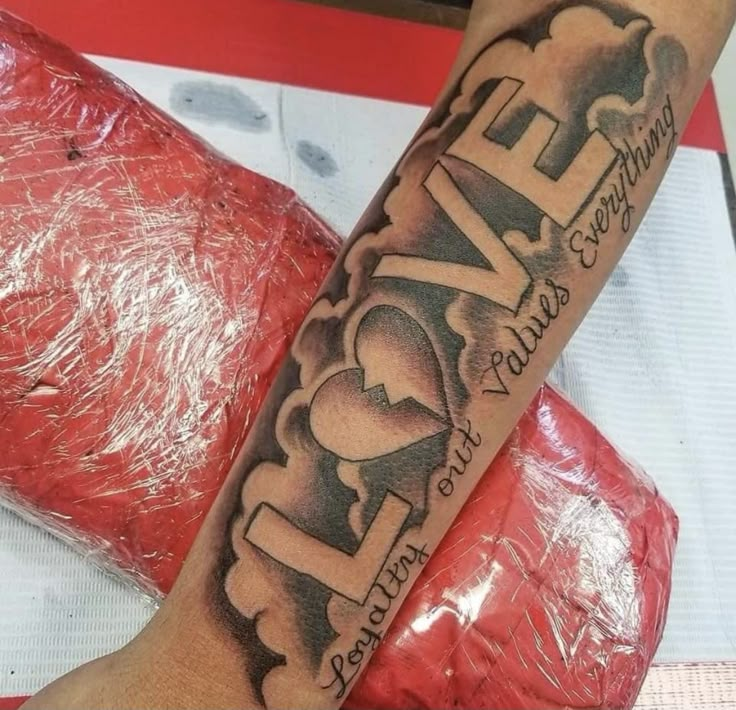 a person with a tattoo on their arm that says live love and has hearts in it