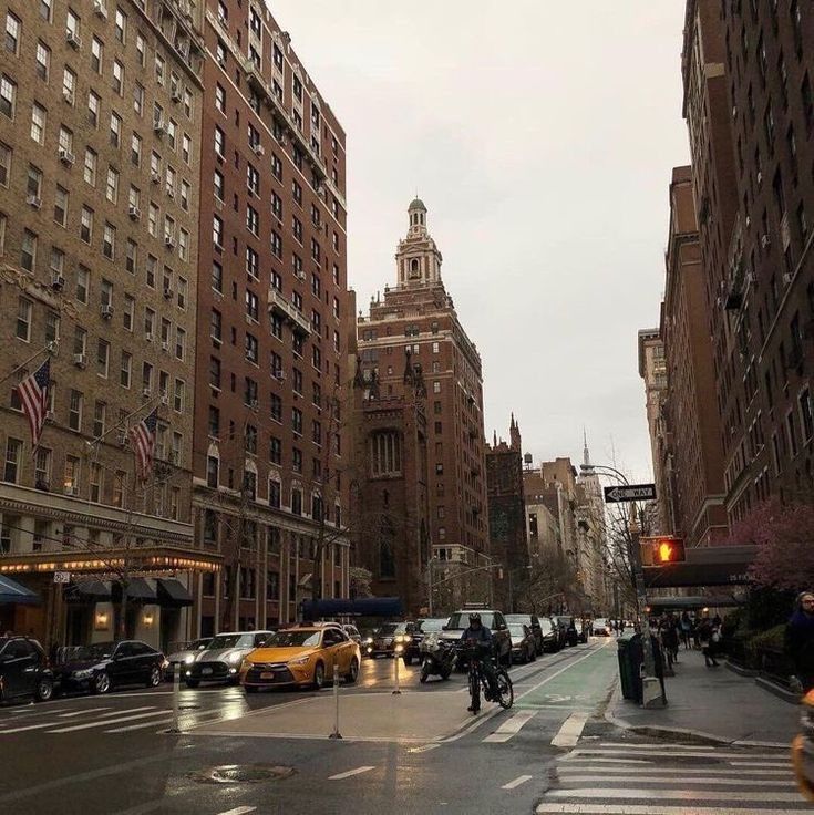 a city street filled with lots of traffic and tall buildings on either side of it