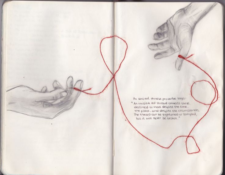 an open book with two hands holding red string