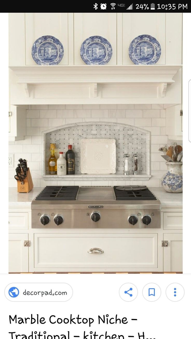 a white kitchen with blue and white plates above the stove