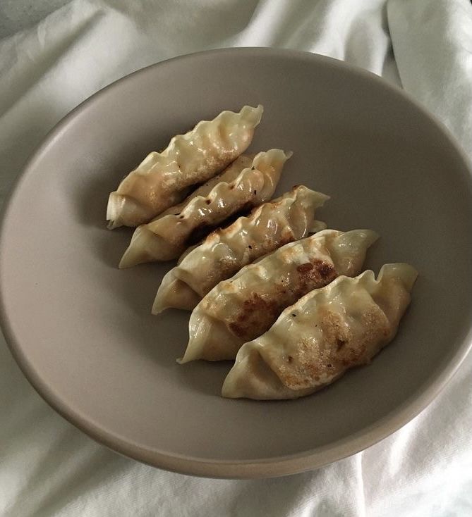 three dumplings are on a plate with white cloth