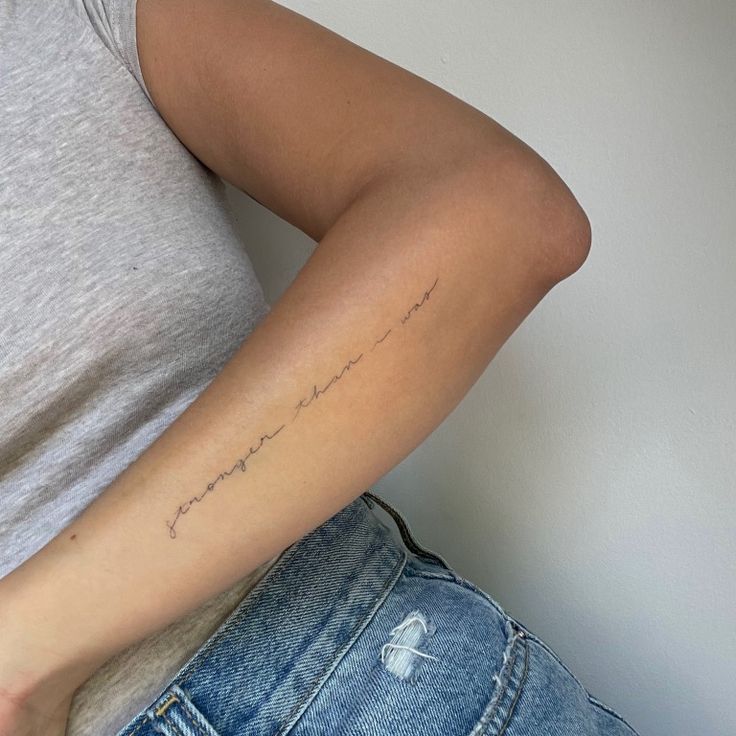 a woman with a tattoo on her left arm and the word love written in cursive writing