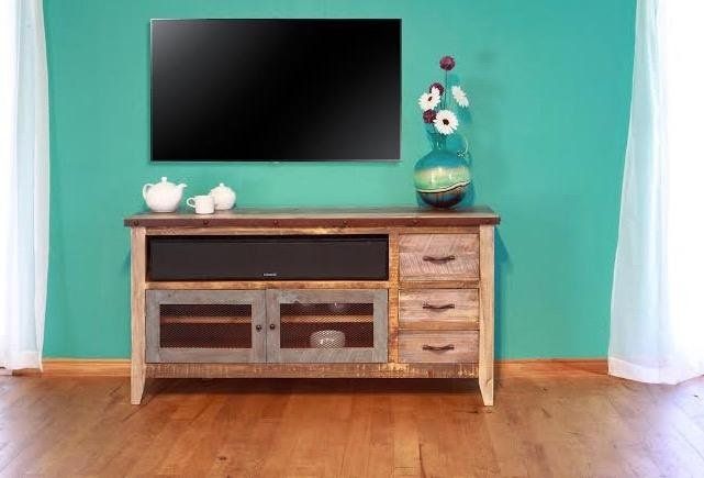 an entertainment center with a flat screen tv mounted on it's side, in front of a teal wall