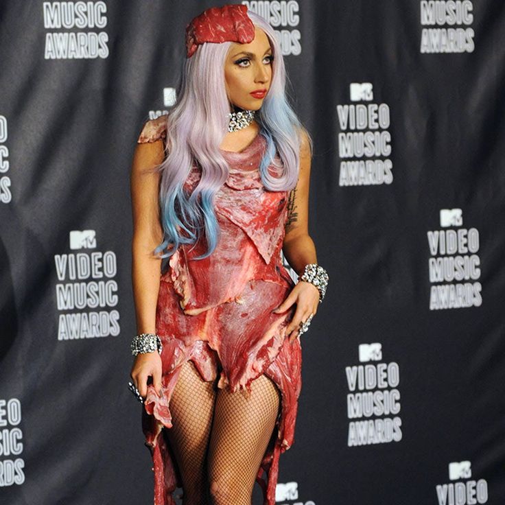 a woman dressed up as a zombie in front of a video music awards backdrop wearing fishnet stockings and thigh high boots