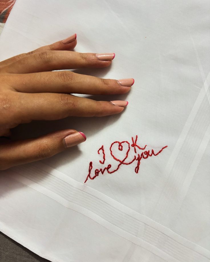 a woman's hand on top of a piece of paper that says i love you