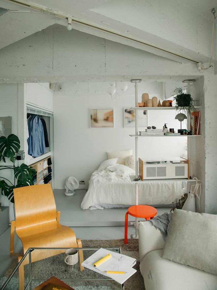 a bedroom with white walls and furniture in it