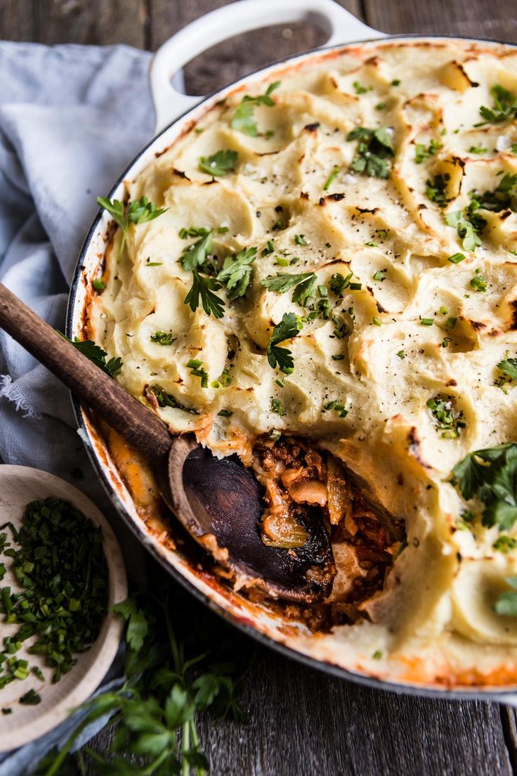 a casserole dish filled with pasta and meat, garnished with parsley