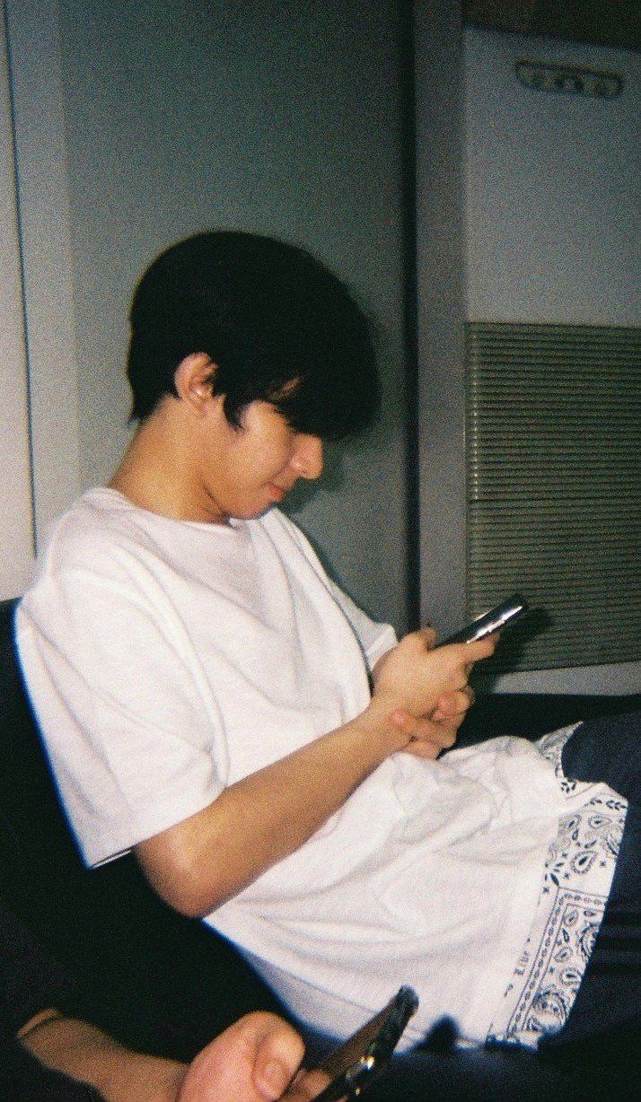 a young man sitting down looking at his cell phone