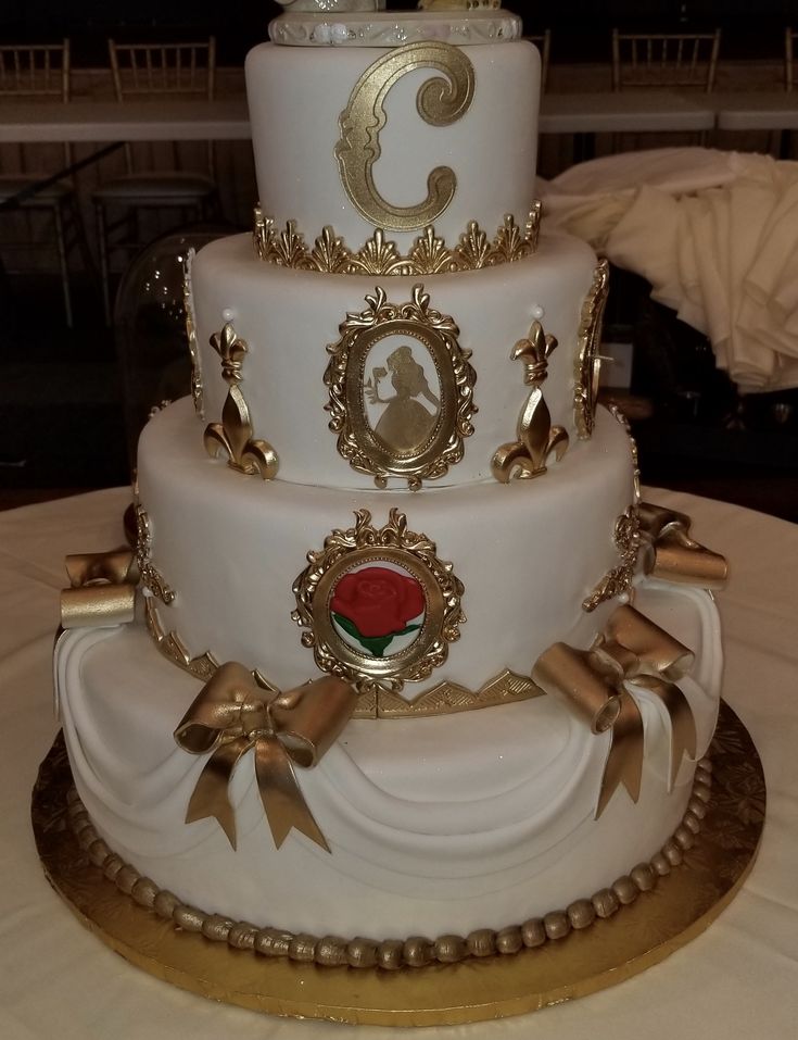 a three tiered white cake with gold decorations