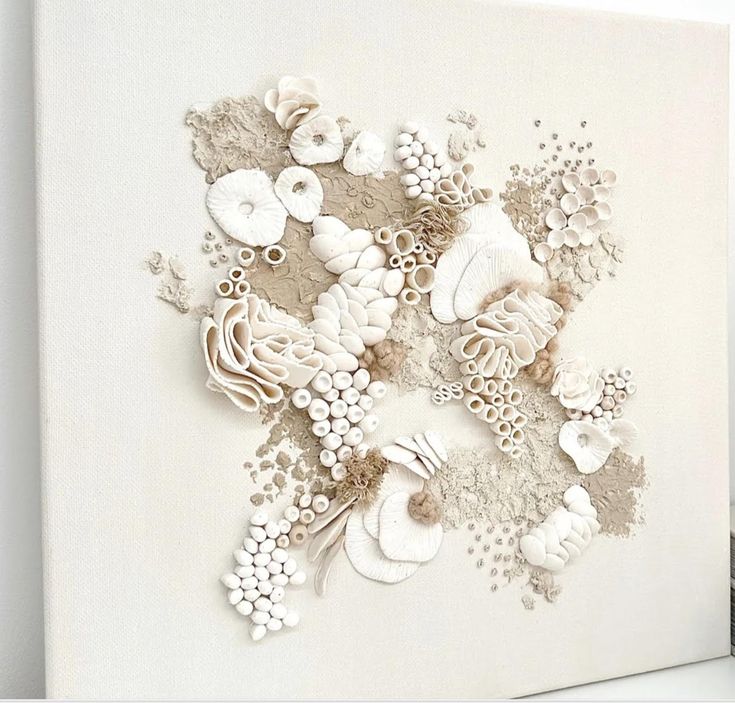 a white painting with flowers and shells on it