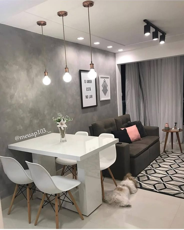 a white table and chairs in a room with grey walls, black and white rug