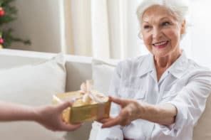 an older woman handing a gift to another person