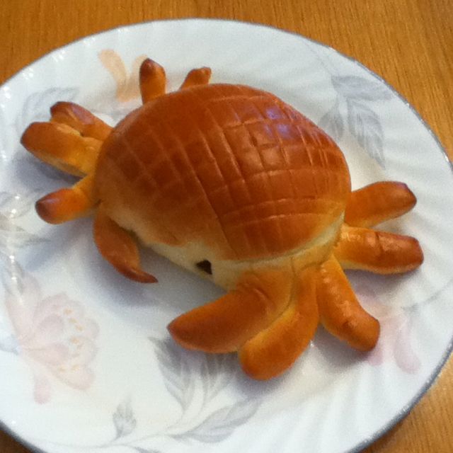 an orange crab on a white plate sitting on a wooden table